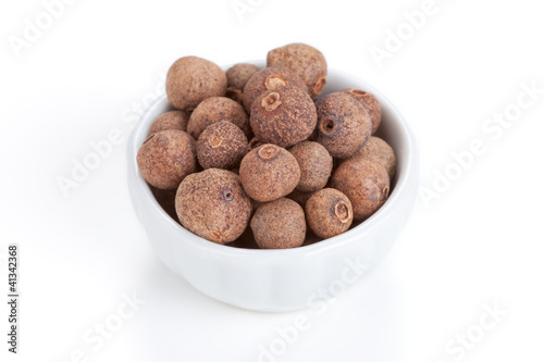 Photo: Pile Allspice in white bowl on white background Pile Allspice in white bowl on white background
