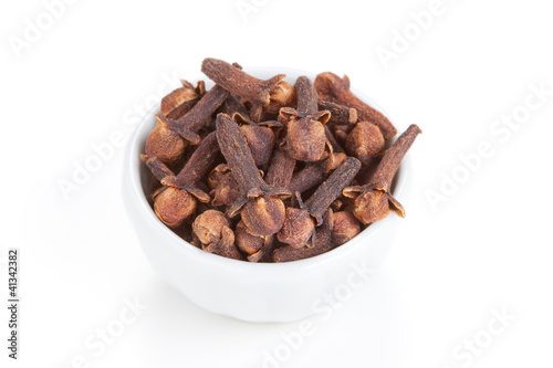 Photo: Clove (Syzygium aromaticum) in a white bowl on white background Clove (Syzygium aromaticum) in a white bowl on white background