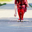Photo: Child girl playing hopscotch on asphalt Child girl playing hopscotch on asphalt
