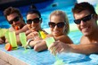 Young couples in swimming pool with cocktail