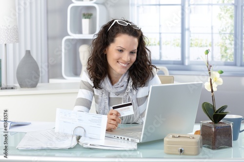 Photo: Smiling woman paying online Smiling woman paying online