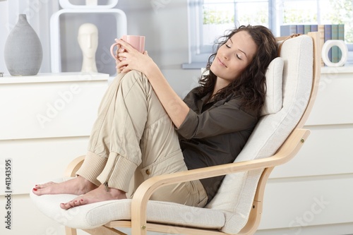 Foto: Woman relaxing in armchair Woman relaxing in armchair