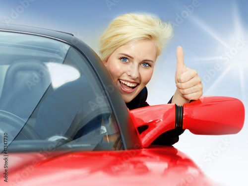 Photo: Beautiful 20s driving a red roadster and shows thumb up Beautiful 20s driving a red roadster and shows thumb up