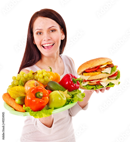 Foto: Woman choosing between fruit and hamburger. Woman choosing between fruit and hamburger.