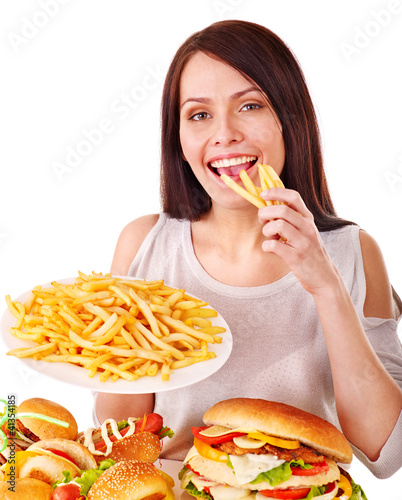 Photo: Woman eating fast food. Woman eating fast food.