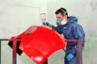 Man painting a red fender.