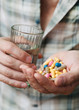 Pills and glass of water in the man hand