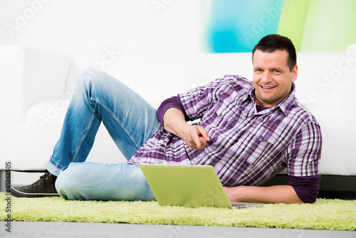 Photo: attraktiver mann zeigt auf sein notebook attraktiver mann zeigt auf sein notebook