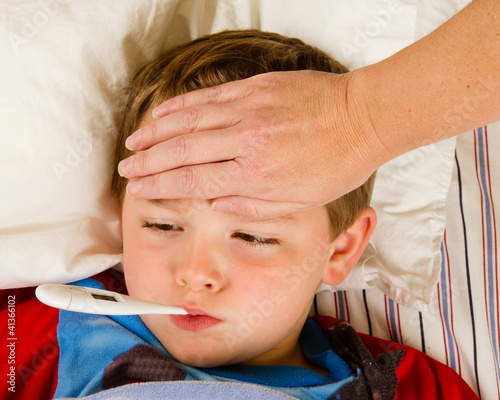 Photo: Sick child being checked for fever Sick child being checked for fever