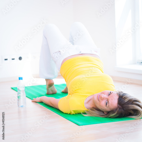 Photo: Pretty young woman doing YOGA exercise at home Pretty young woman doing YOGA exercise at home