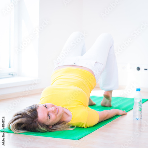Photo: Pretty young woman doing YOGA exercise at home Pretty young woman doing YOGA exercise at home