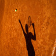 shadow of a tennis player in action on a tennis court