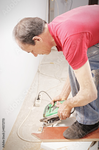 Photo: Guy sawing off plank Guy sawing off plank