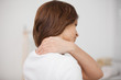 Brown-haired woman massaging her painful neck