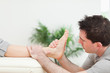 Physiotherapist sitting while massaging a foot