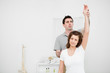 Serious osteopath raising the arm of a patient