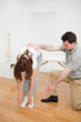 Doctor looking at a patient who is doing stretching exercises