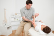 Physiotherapist holding the arm of a brunette woman