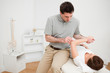 Serious doctor looking at the arm of a patient