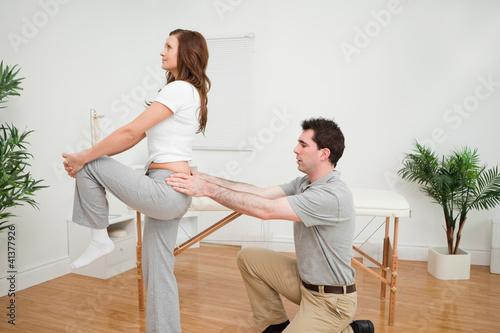 Photo: Serious woman stretching her leg Serious woman stretching her leg