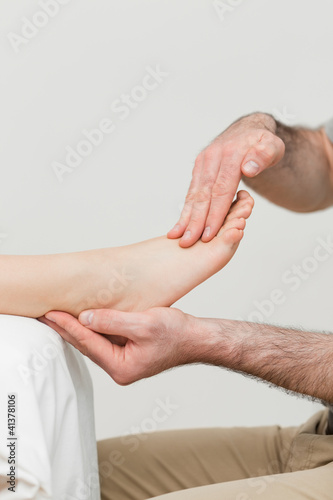 Photo: Practitioner holding the foot of a patient Practitioner holding the foot of a patient