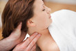Therapist massaging the neck of woman while holding her head