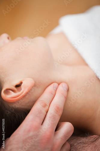 Photo: Close-up of doctor pressing two fingers on the neck of his patie Close-up of doctor pressing two fingers on the neck of his patie