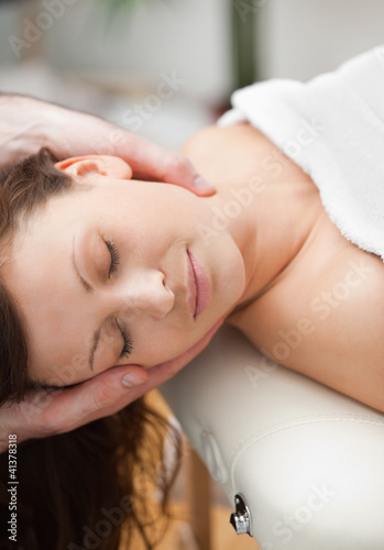 Photo: Peaceful woman being massaging on the neck by a therapist Peaceful woman being massaging on the neck by a therapist