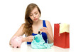 Unhappy woman with shopping bags and piggybank