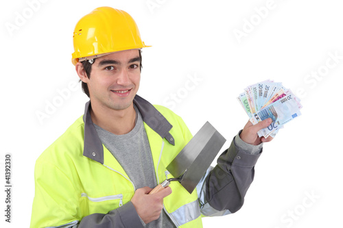 Photo: Tradesman holding a trowel and cash Tradesman holding a trowel and cash
