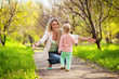 Young Mother walking with her baby in spring garden