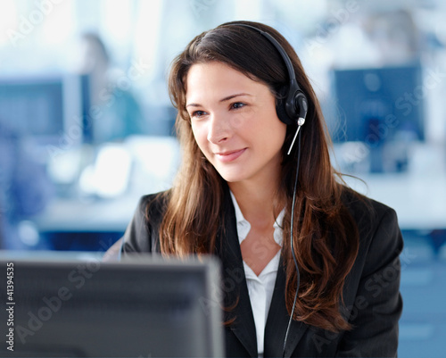 Photo: Woman with headset in the office Woman with headset in the office