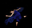 Caucasian beauty in blue dress floating in black