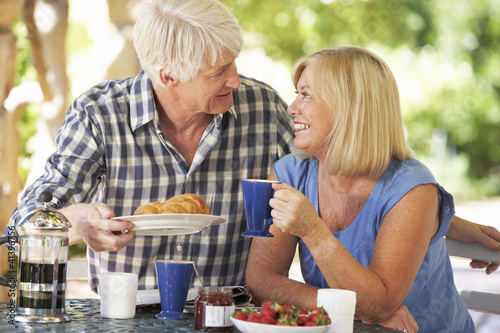 Photo: Senior couple eating breakfast outdoors Senior couple eating breakfast outdoors