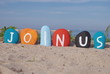 join us, message on colourful pebbles on the sand