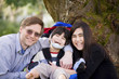 Disabled boy in wheelcahir surrounded by father and sister