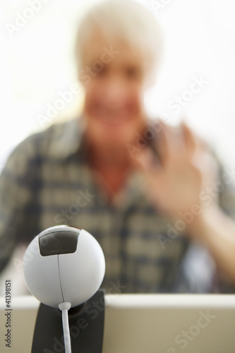 Photo: Mid age man using skype Mid age man using skype