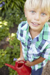 Young boy watering garden