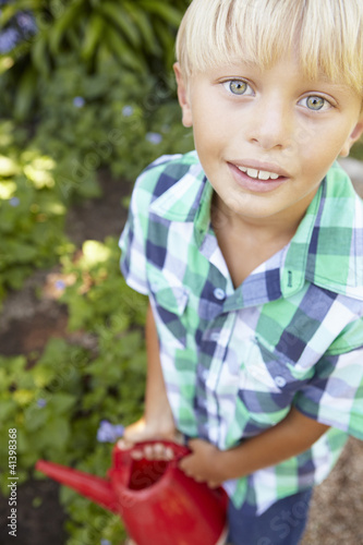 Photo: Young boy watering garden Young boy watering garden