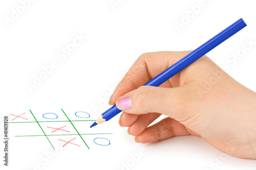 Photo: Hand with pencil and game Hand with pencil and game