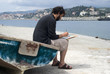 Painter painting a picture sitting on old row boat Painter painting a picture sitting on old row boat