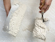 notched trowel and worker hands on tile