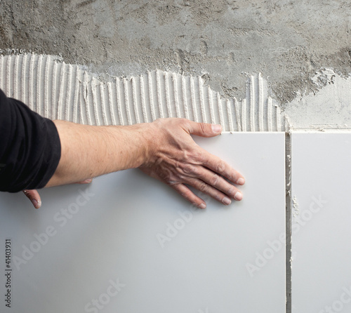 Foto: construction mason man hands on tiles work construction mason man hands on tiles work