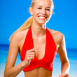 Young happy woman running on beach