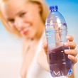 Woman with bottle of water on beach