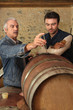 Two men checking quality of wine