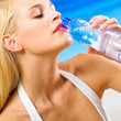 Woman with bottle of water on beach
