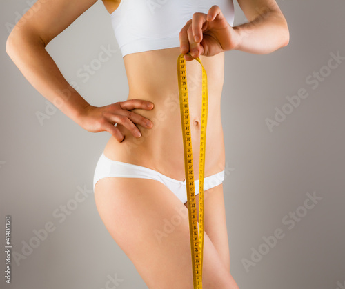 Foto: Woman measuring her slim body Woman measuring her slim body