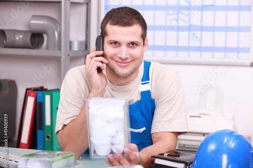Foto: Plumber in an office checking a part Plumber in an office checking a part