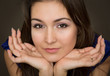Portrait of beautiful young brunette woman propping up her face